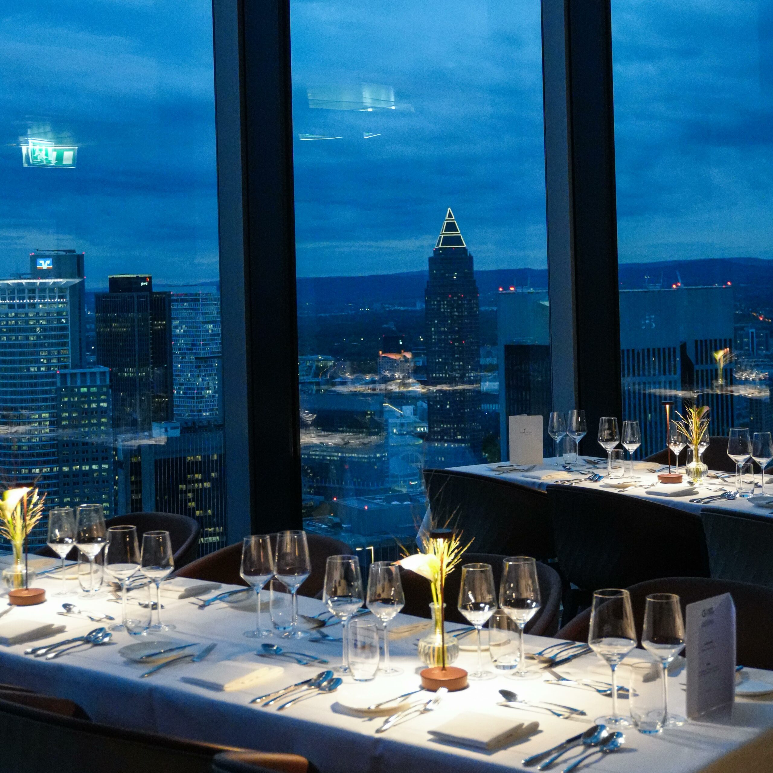 Tables overlooking Frankfurt at dusk at MAIN TOWER Restaurant